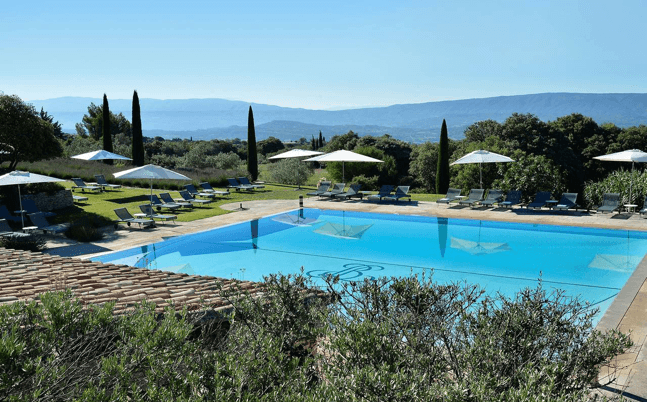 Piscine et oliviers face aux collines, cadre d'un séjour bien-être en Provence
